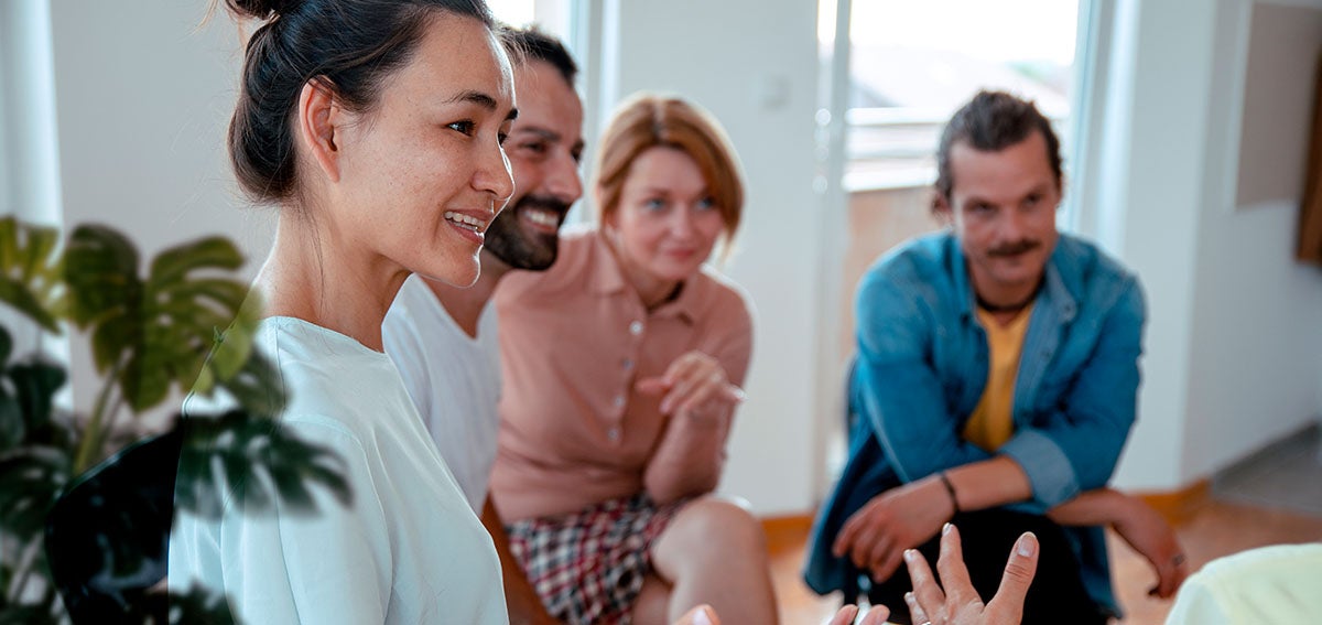 Group of men and women sitting together talking.